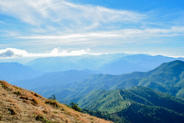 Fototapeta premium Scenic Mountain Landscape with Blue Sky and Layers of Misty Hills