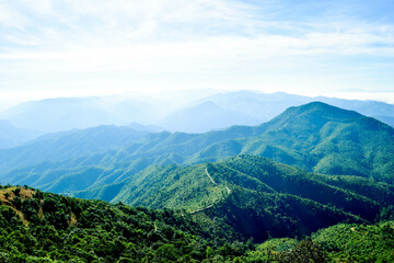 Fototapeta premium Scenic Mountain Landscape with Blue Sky and Layers of Misty Hills