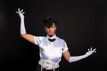 Young dancer performing with white gloves and corset on black background