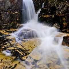 Beautiful autumn river flowing over a waterfall in Norway surrounded by rocky terrain