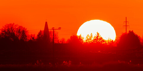 Megazoom (600mm) winter sunset or sundowner with a church silhouette near Wallersdorf, Dingolfing-Landau, Bavaria, Germany