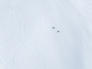 Alpine skiers on their way up to the top, and some skiers on their way down. Norwegian winter mountain landscape.