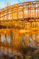 Winter landscape with an old railway bridge and reflections on a sunny evening near Landau an der Isar, Dingolfing-Landau, Bavaria, Germany