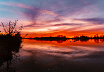 High resolution stitched winter sunset or sundowner panorama with reflections near Plattling, Isar,...