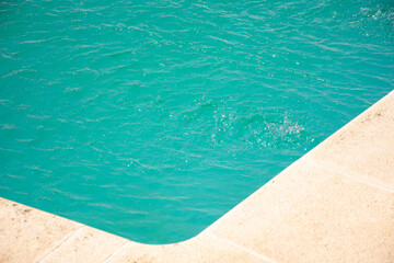corner of a swimming pool with clear blue water