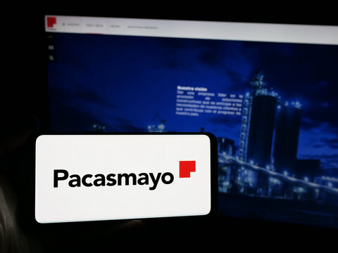 Stuttgart, Germany - 04-09-2025: Person holding smartphone with logo of Peruvian company Cementos Pacasmayo S.A.A. on screen in front of website. Focus on phone display.