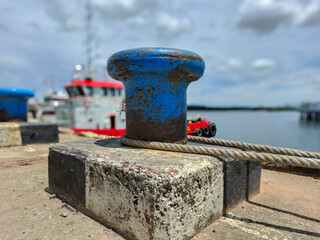 Mooring bollard with rope to tie the ship when docked in the harbor