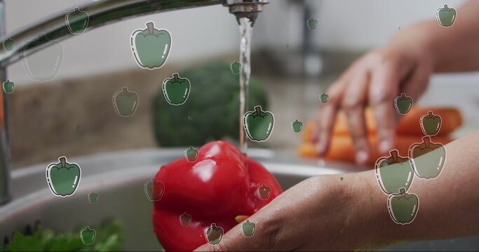 Image of pepper icons over caucasian man washing vegetables