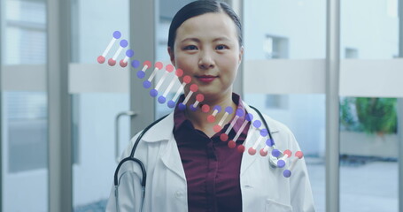 Image of asian female doctor smiling over dna strand