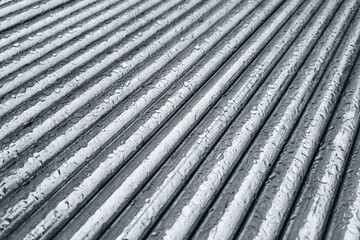 Wet metal surface. Raindrops on texture. Reflective industrial pattern. Silver pipes closeup. Shiny...