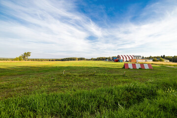 rural airfield with red barn and blue sky