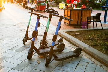 Eco-scooters parked on the streets of the city, city scooter rental, alternative modes of transport