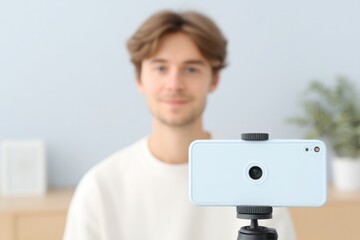 Naklejka premium young creator filming video with smartphone on tripod minimalistic room setup clean background