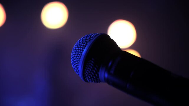 Microphone on stage with blurred concert lights in background