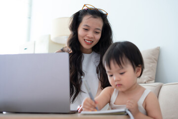Mom and baby girl is playing together at home