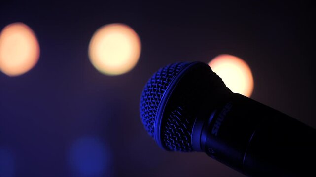 Microphone on stage with blurred concert lights in background