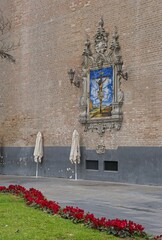 Seville, Spain - Mar 23, 2025: Walking in Seville. Ceramic altarpiece of the Christ of the Good Death. Streets, buildings. Lifestyle in the urban area. Cloudy spring day. Selective focus
