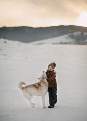 A boy hugs his dog tightly