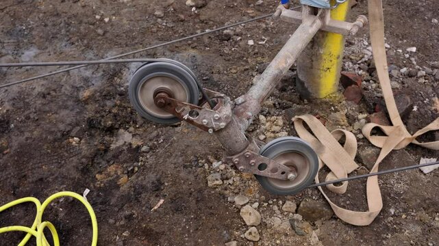 Wire saw guide pulleys in action as spinning and guiding diamond wire cutting structural elements on building site