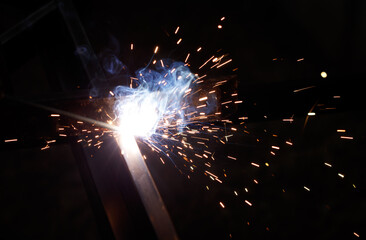 A black and white photo of sparks flying from a welding machine
