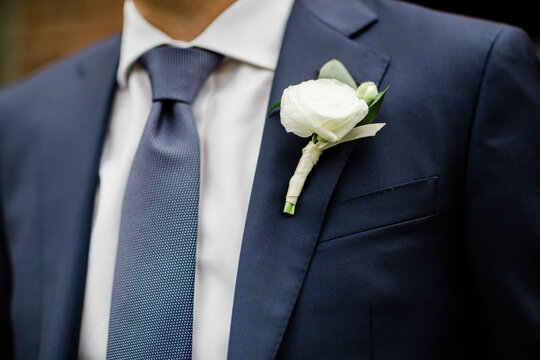 groom in a blue suit and boutonni&egrave;re 