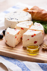 Homemade organic white cheese served with crispy bread, walnut and olive oil on wooden board on the table. Healthy food, snack and eating.