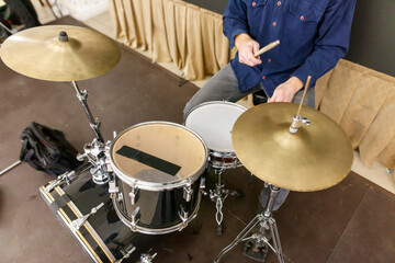 A man is playing drums with two cymbals