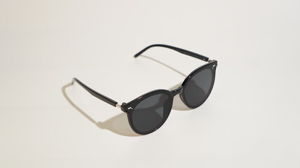 Elegant dark sunglasses angled on a simple, bright surface displaying modern design