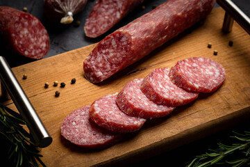 Chopping board with sliced salami. Italian sausage. Close up