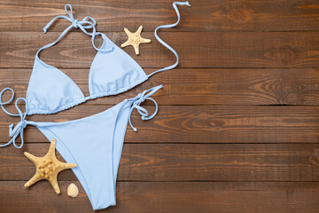 Blue bikini on wooden background, top view