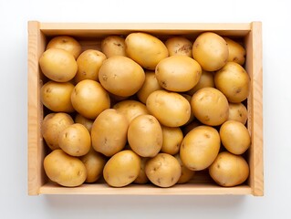 Top view perspective of fresh raw yellow potatoes completely filling a rustic wooden crate on white background.