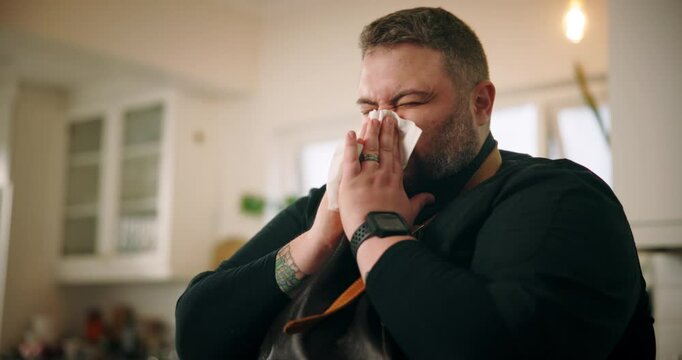 Sick man, chef and blowing nose with tissue for influenza, viral infection or virus at home. Male person, flu or cold with hayfever, sinus or allergy of illness for bacteria, germs or sneeze at house