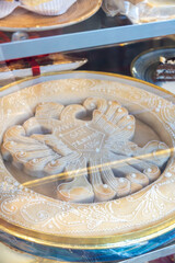 A delicious pie adorned with a cross design rests inside a glass case