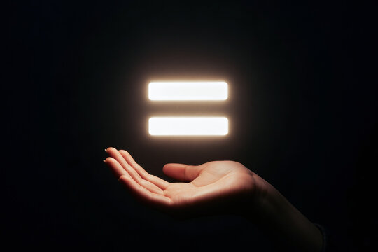 A hand reaches out, showcasing two glowing parallel bars, symbolizing balance and equality against a dark background.