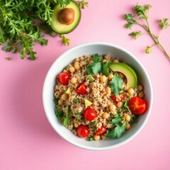 Healthy couscous salad with chickpeas, avocado, and cherry tomatoes on pink background. Top view.