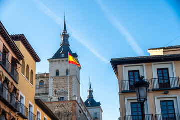 A vibrant Spanish flag waves in the wind against a blue sky