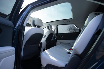 Panoramic glass sun roof in the modern electric car. Clean sunroof and view at the sky from the...