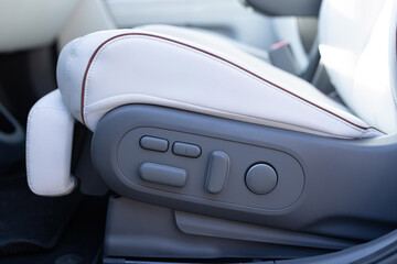 Driver's seat adjustment buttons. Buttons for adjusting seat position. Car interior. Furniture Adjustment Button Activated Power Seat Expensive White Leather