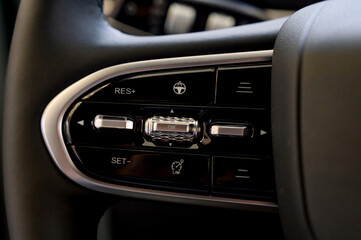 Obraz premium A close-up of a modern car's steering wheel with control buttons