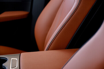 Interior view of a car showcasing brown leather seats with black seat belts.