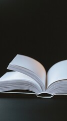 An open book with pristine white pages spread wide, revealing its spine and inner structure against a dark, minimalist background, symbolizing knowledge and literary exploration.