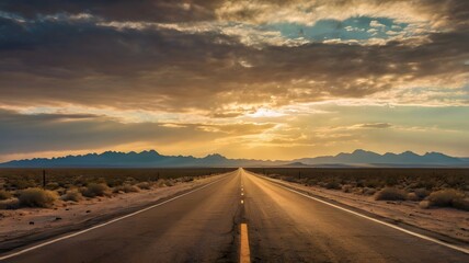 Naklejka premium Desert Highway at Sunset with Mountain Range and Dramatic Sky