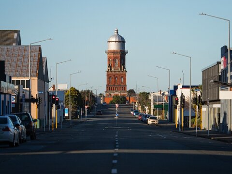 Urban city cityscape road leading to historical red brick stone Invercargill water tower storage with cupola in Southland South Island New Zealand