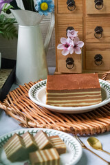 A traditional Indonesian steamed layer cake with alternating vibrant layers, showcasing a soft, moist texture and rich flavors, perfect for festive occasions.