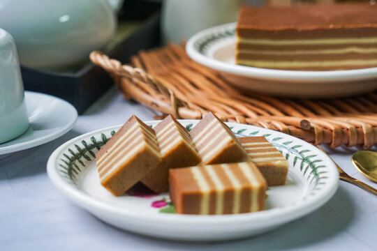 A traditional steamed layer cake with alternating vibrant layers, showcasing a soft, moist texture and rich flavors, perfect for festive occasions.