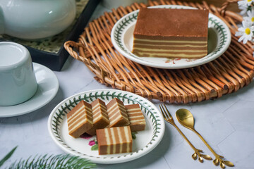 A traditional steamed layer cake with alternating vibrant layers, showcasing a soft, moist texture...