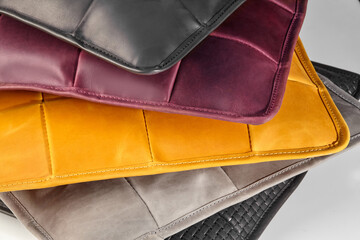 Stack of colorful leather placemats showing stitching detail