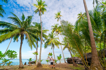 Father and son walking on tropical seaside 