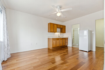 A vacant room featuring polished hardwood floors and a ceiling fan