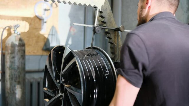 Car alloy wheel repair. Mechanic measures the difference in rim height